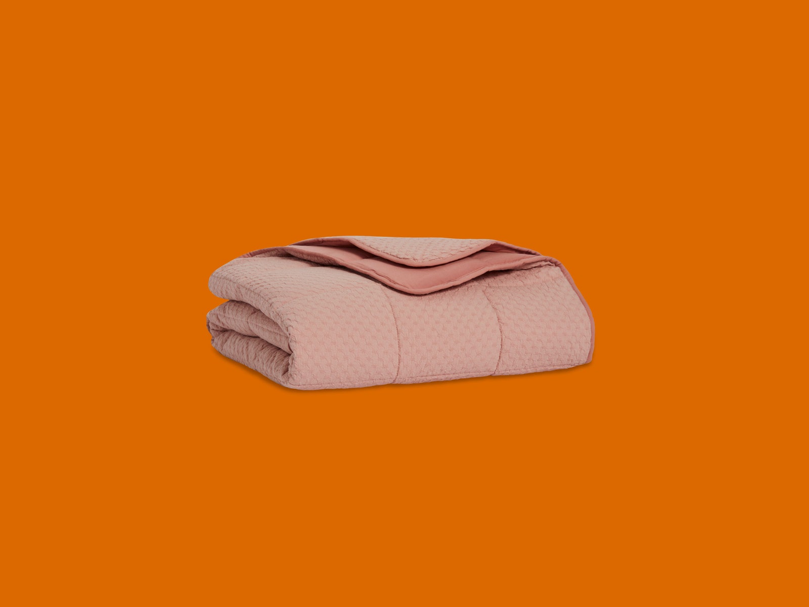 pink Brooklinen blanket on orange background